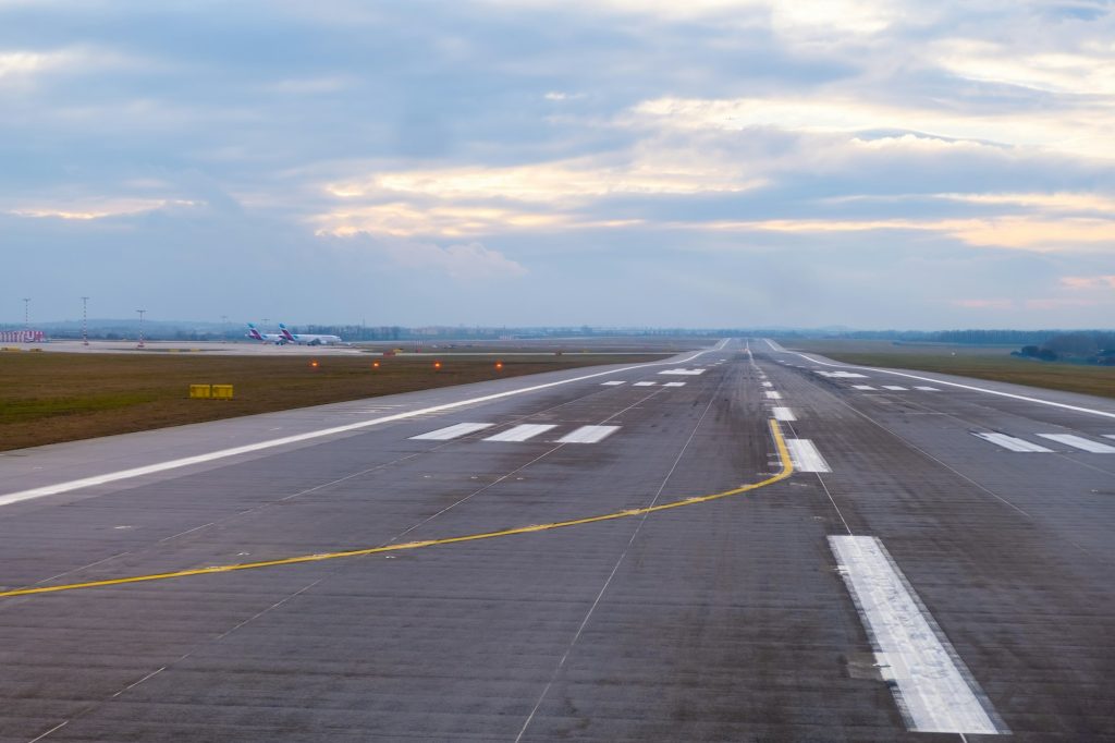 A long, straight runway stretches into the distance at the airport.