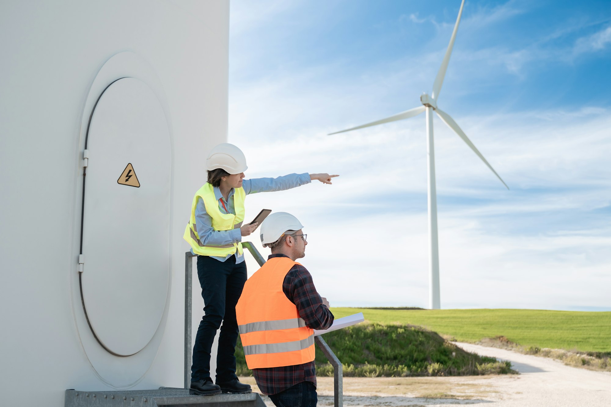 Green power energy - People working at sustainable alternative farm with turbine on background