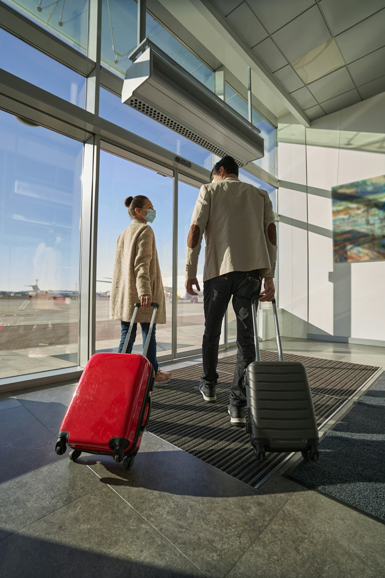 Pair of people pulling their suitcases while going to runway