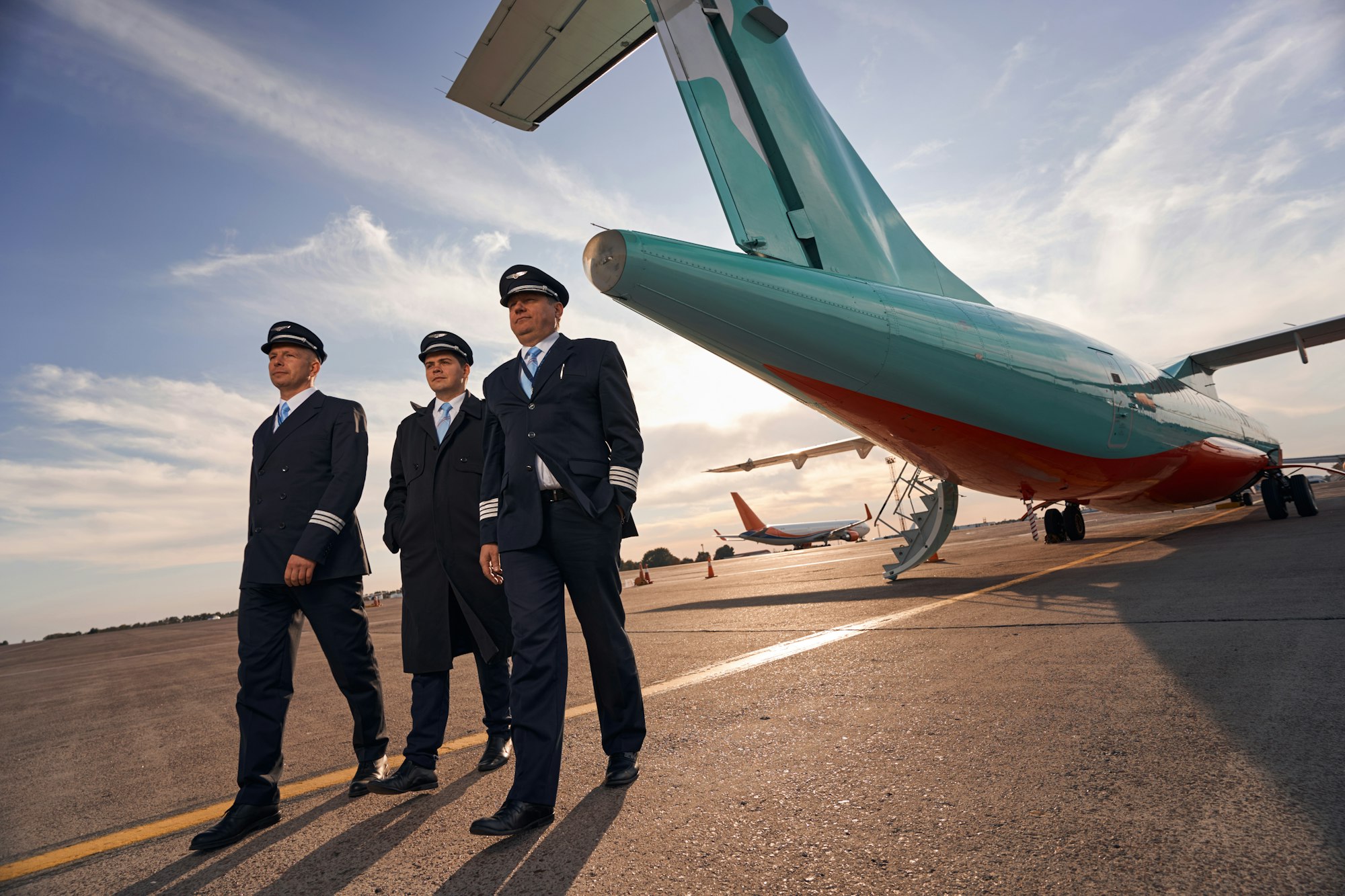 Three plane captains making a step forward from airplane
